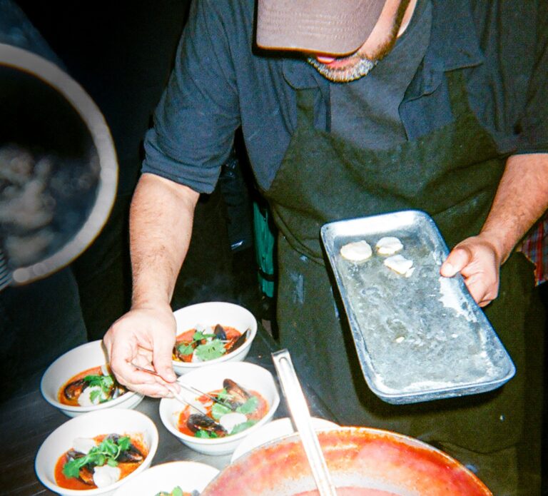A chef makes the final touches to dishes at a BURNTORANGEHONEY event.